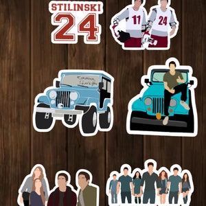 May include: A set of stickers featuring characters and objects from the popular TV show Teen Wolf. The stickers include a blue Jeep with the words "Remember I Love You" written on the windshield, a group of characters standing together, two characters wearing hockey jerseys with the numbers 11 and 24, and a character sitting on a blue Jeep.