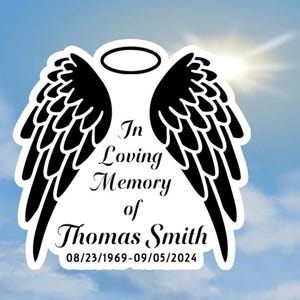 May include: Black and white memorial sticker with angel wings and a halo. The text reads "In Loving Memory of Thomas Smith 08/23/1969-09/05/2024".
