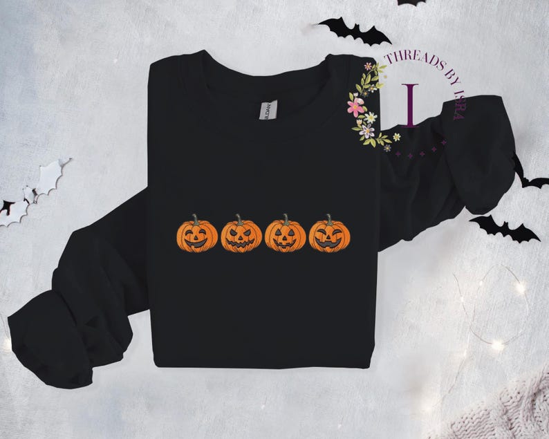 Pu&ograve; includere: Maglietta nera a maniche lunghe con una grafica di quattro zucche arancioni a forma di jack-o'-lantern con diverse espressioni facciali.