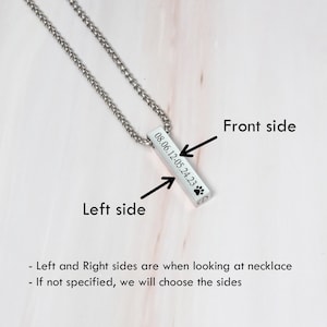 May include: Silver necklace with a rectangular pendant engraved with the date "08.06.12-05.24.23" and a paw print. The pendant is on a silver chain.