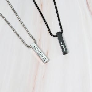 May include: Two silver bar necklaces with engraved text. One necklace has the Roman numeral date "VIII.II.MMXX" and the words "I love you". The other necklace has the name "Jayden" engraved on it.