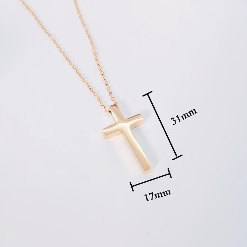 May include: A gold-tone cross pendant necklace with a simple, minimalist design. The pendant measures 1.22 inches in length and 0.67 inches in width.