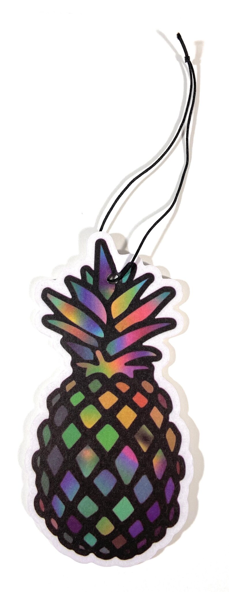 May include: A colorful pineapple-shaped air freshener with a black string for hanging. The pineapple design features a rainbow gradient on the top and a diamond pattern in shades of green, purple, and black.