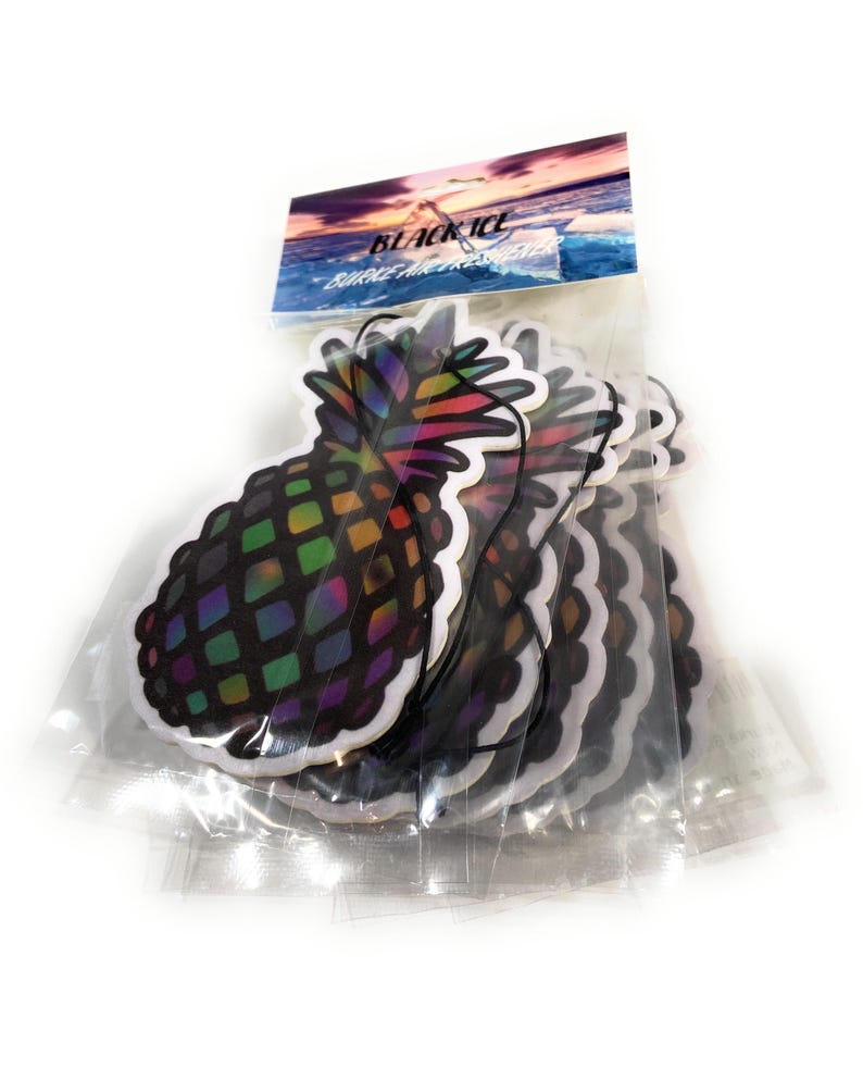 May include: A package of pineapple-shaped air fresheners. Each sticker has a black background with a colorful, geometric design. The packaging has the words "BLACK ICE" and a scenic image of a sunset over the ocean.