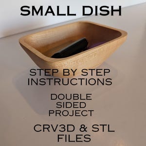 Puede incluir: Un pequeño cuenco de madera de color claro con forma rectangular. El cuenco contiene un objeto negro. El texto de la imagen dice "SMALL DISH", "STEP BY STEP INSTRUCTIONS", "DOUBLE SIDED PROJECT" y "CRV3D & STL FILES".