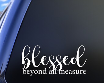 May include: White vinyl decal with the words "Blessed beyond all measure" in a cursive font. The decal is applied to a dark surface, possibly a car window, with a blue sky visible in the background.