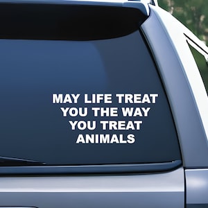 May include: A white vinyl sticker with the text "May life treat you the way you treat animals" on a blue car window.