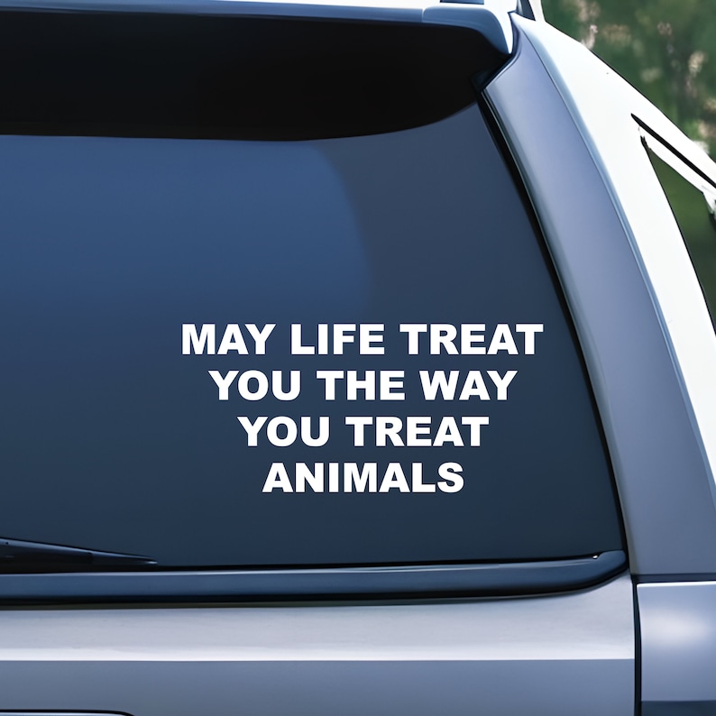 May include: A white vinyl sticker with the text "May life treat you the way you treat animals" on a blue car window.
