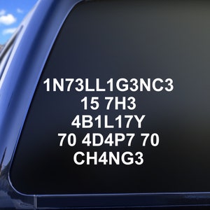 May include: A white sticker on a black car window with the text "1N73LL1G3NC3 15 7H3 4B1L17Y 70 4D4P7 70 CH4NG3"
