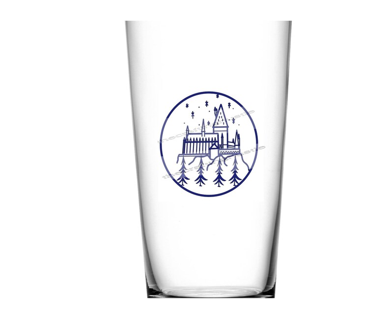 May include: A clear glass cup with a blue and white illustration of Hogwarts castle in a circle. The castle is surrounded by trees and stars.