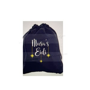 May include: A black drawstring bag with the text "Musa's Eidi" in white lettering and gold stars hanging from the text.