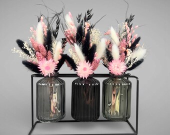 Vases in a metal stand with dried flowers. Modern table decoration.