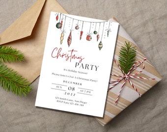 Puede incluir: Una invitación a una fiesta de Navidad con adornos de acuarela colgando de una cuerda. La invitación blanca tiene texto rojo y negro, y está sobre un regalo envuelto y un sobre marrón. La invitación incluye la fecha, la hora y el lugar.