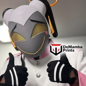 May include: A gray and white character mask with gold mesh eyes, a gold halo, and a yellow smile. The wearer is dressed in a white jacket with pink accents and silver buttons, wearing black gloves with two white stripes. Text reads DeMamba Prints.