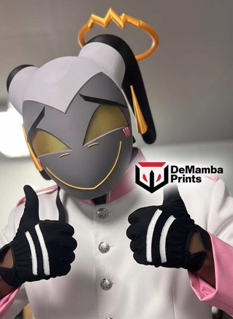 May include: A gray and white character mask with gold mesh eyes, a gold halo, and a yellow smile. The wearer is dressed in a white jacket with pink accents and silver buttons, wearing black gloves with two white stripes. Text reads DeMamba Prints.