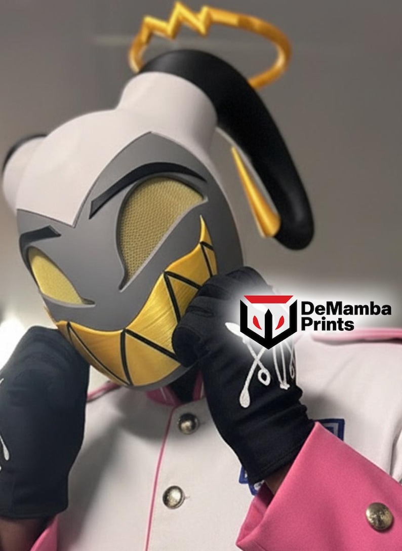 May include: A white, gray, and yellow character mask featuring a gold halo, mesh eye coverings, and a wide, jagged yellow grin. The mask is worn with black gloves featuring white graphic details and a white jacket with pink trim and silver buttons.