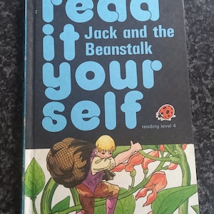 May include: A book cover with the title "read it yourself" in large blue letters. The book is about Jack and the Beanstalk. A cartoon illustration of a boy carrying a sack climbing a beanstalk is on the cover.