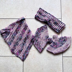 Könnte beinhalten: Ein Set handgestrickter Accessoires in Rosa-, Lila- und Blautönen. Das Set umfasst einen Schal, ein Stirnband und ein Paar Fäustlinge. Die Artikel sind mit einem strukturierten Stich gefertigt und auf einer hell gefliesten Oberfläche angeordnet.