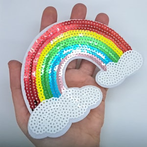 May include: A rainbow-coloured sequin patch with white clouds. The rainbow is made of red, orange, yellow, green, blue, indigo, and violet sequins. The clouds are made of white sequins.