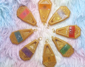 Amuleto de anime con crestas de diferentes colores (coraje, luz, amistad, conocimiento, amor, sinceridad, pureza, esperanza)