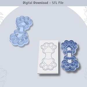 Puede incluir: Dos cortadores de galletas de plástico azul en forma de huella de pata con un corazón en el centro. Los cortadores están sobre un fondo blanco con el texto "Descarga digital - Archivo STL".