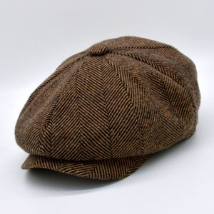 May include: A brown and black herringbone patterned newsboy cap.