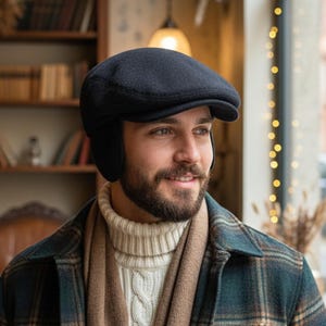 May include: A dark navy blue newsboy cap with ear flaps. The cap is worn with a cream-colored cable knit sweater, a brown scarf, and a plaid jacket. The image is a medium shot, with a warm, inviting atmosphere.