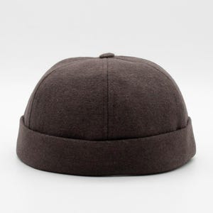 May include: A brown wool beanie with a rounded crown and a folded brim.