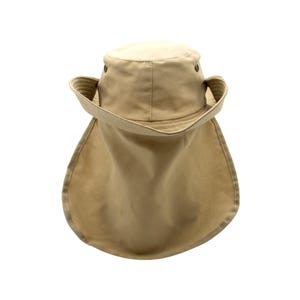 May include: A tan-colored sun hat with a wide brim and a neck flap. The hat has a rounded crown and a structured brim. The neck flap extends down the back, offering additional sun protection. The hat is made of a durable fabric.