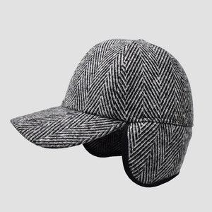 May include: A black and white herringbone patterned baseball cap with ear flaps. The cap has a curved brim and a structured crown.