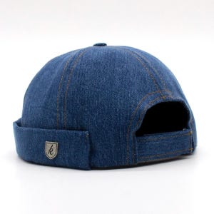 May include: A blue denim bucket hat with a small metal logo on the front.