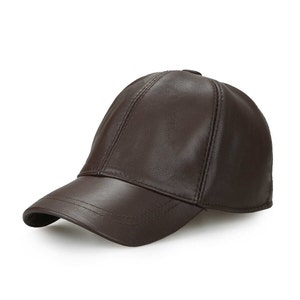 May include: A brown leather baseball cap with a curved brim. The cap has a classic six-panel design with stitched seams and a button on top. The leather has a smooth, glossy finish.