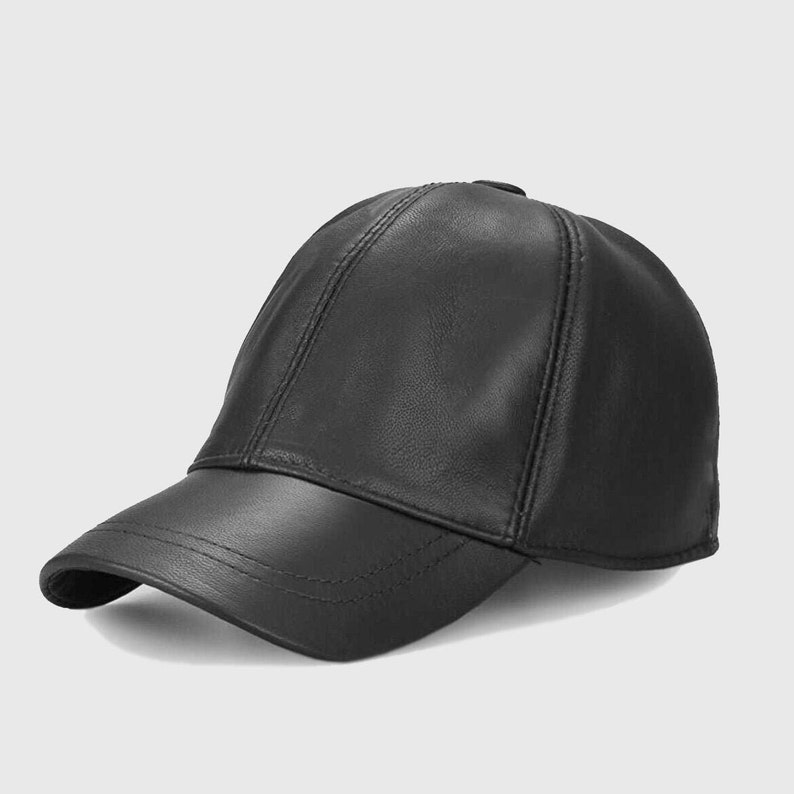 May include: A black leather baseball cap with a curved brim. The cap has a classic six-panel design with stitched seams and a button on top. The hat is made of a smooth, shiny leather material.