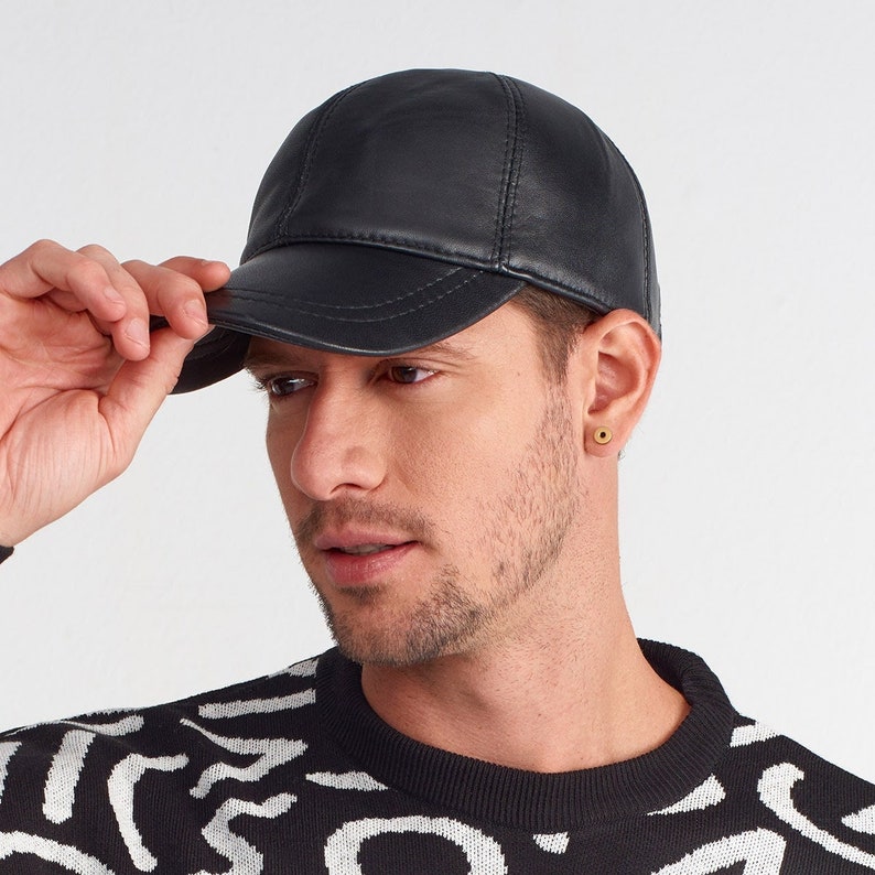 May include: A black leather baseball cap with a curved brim. The cap has a classic design and is made of high-quality leather.