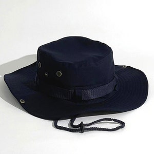 May include: A dark blue, wide-brimmed sun hat with a chin strap and a buckle closure. The hat has a flat top and a wide brim that can be folded down.