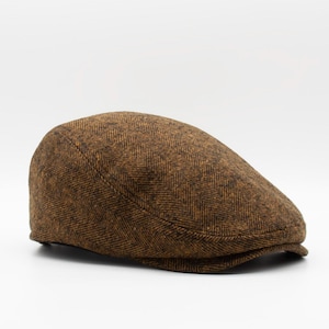 May include: A brown tweed flat cap with a herringbone pattern.