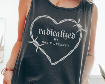 May include: Dark gray tank top with a white heart-shaped design made of barbed wire. The text inside the heart reads "radicalized by BASIC DECENCY". The tank top is sleeveless and made of a soft material.