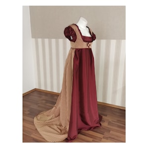 May include: A long, burgundy and gold striped dress with a fitted bodice and a flowing skirt. The dress has a square neckline and short sleeves.