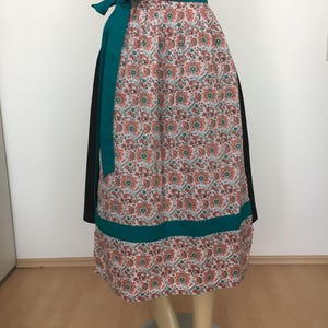 Könnte beinhalten: Ein langer, schwarz-weißer Rock mit Blumenmuster. Der Rock hat einen türkisfarbenen Bund und einen Saum.