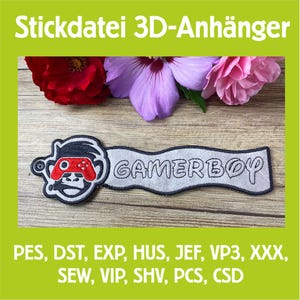 Könnte beinhalten: Ein Gamerboy-Patch mit einem affenähnlichen Charakter, der einen Gamecontroller hält. Der Patch ist weiß mit schwarzem Rand und dem Wort "GAMERBOY" in der Mitte. Der Text "Stickdatei 3D-Anhänger" steht oben.