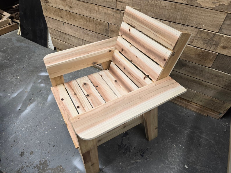 May include: A wooden chair with a slatted back and seat. The chair is made of natural wood and has a simple, rustic design.