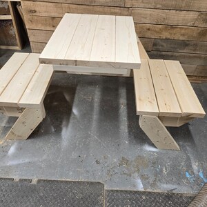 May include: A wooden picnic table with two benches. The table and benches are made of unfinished light wood.