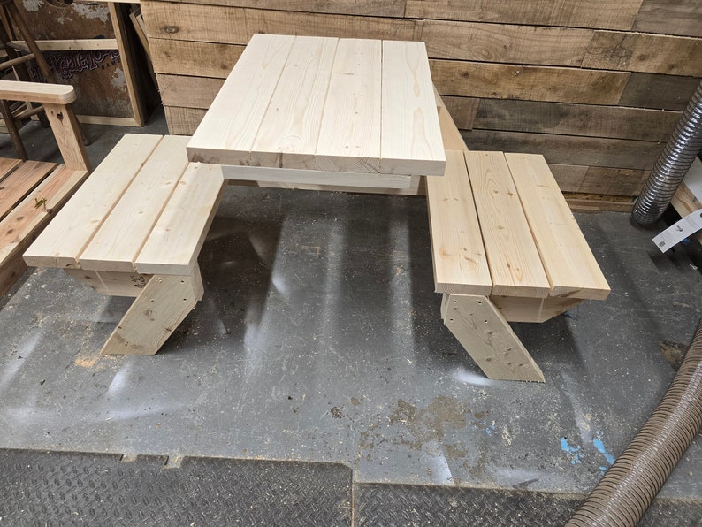 May include: A wooden picnic table with two benches. The table and benches are made of unfinished light wood.