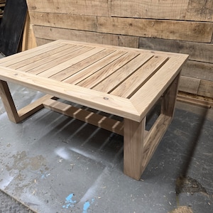 May include: A wooden coffee table with a slatted top and a simple, rectangular frame. The table is made of light-colored wood and has a natural finish.