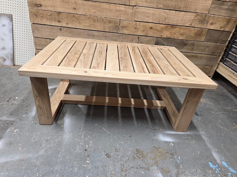 May include: A rectangular wooden coffee table with a slatted top and a simple, modern frame. The table is made of light-colored wood and has a natural finish.