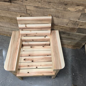 May include: A wooden chair with a slatted back and seat. The chair is made of natural wood with a light brown color.