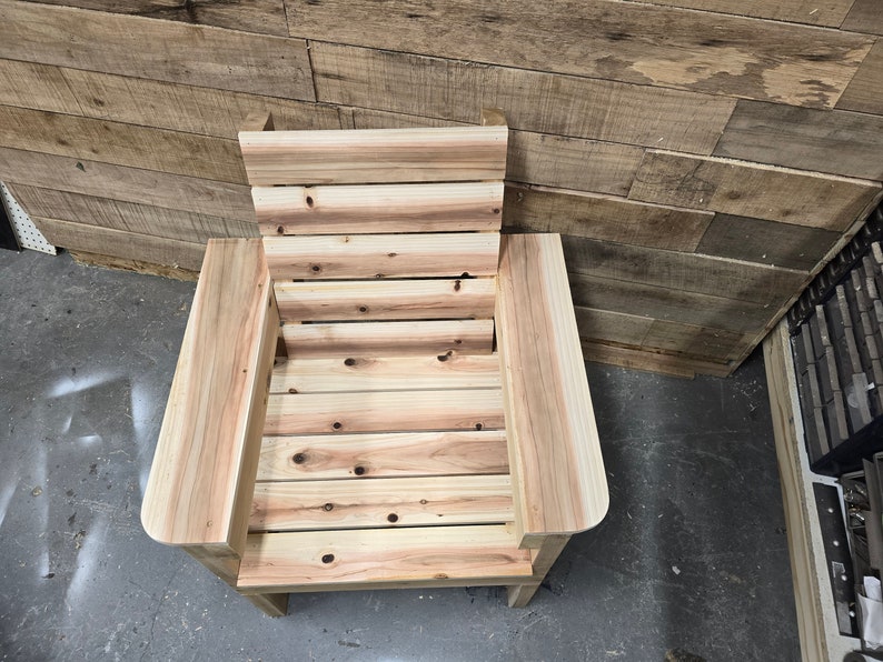 May include: A wooden chair with a slatted back and seat. The chair is made of natural wood with a light brown color.
