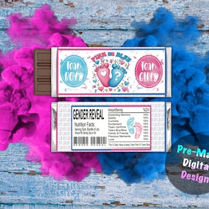 Puede incluir: Un envoltorio de barra de chocolate con un diseño de revelación de género rosa y azul. El envoltorio presenta un signo de interrogación, huellas de pies de bebé y el texto "¿Rosa o Azul?"  "Team Boy" y "Team Girl". El envoltorio también incluye una etiqueta de información nutricional con el texto "Revelación de género".