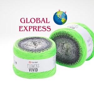 Może przedstawiać: Dwa motki przędzy YarnArt Flowers Vivid. Przędza ma gradient zieleni, szarości i bieli. Etykieta na przędzy głosi "Flowers Vivid". Słowa "GLOBAL EXPRESS" są w czerwonym tekście nad przędzą.