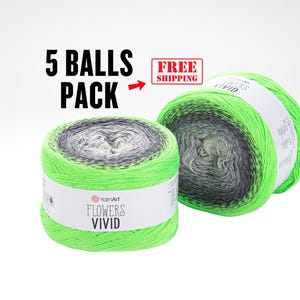 May include: Two balls of YarnArt Flowers Vivid yarn in a vibrant green, gray, and white color gradient. The packaging indicates a 5-ball pack. The yarn is ideal for knitting and crochet projects.